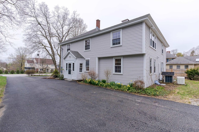 rear view of property featuring a chimney