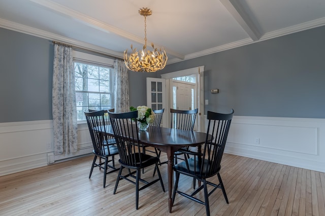 dining area featuring light wood-style floors, a baseboard radiator, a healthy amount of sunlight, and a notable chandelier