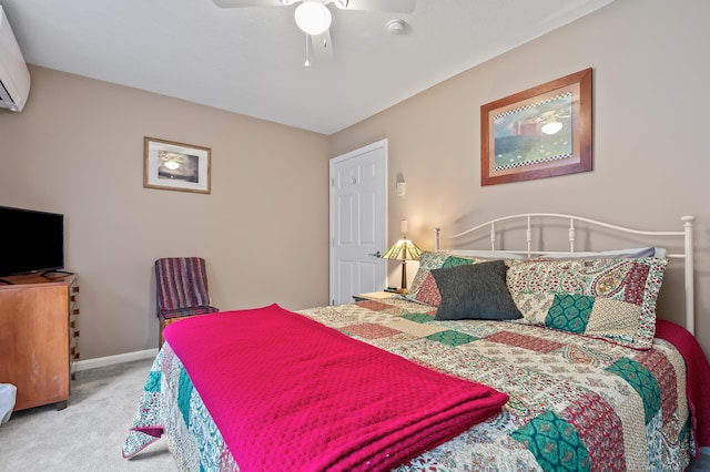 bedroom featuring carpet, baseboards, a wall mounted AC, and a ceiling fan