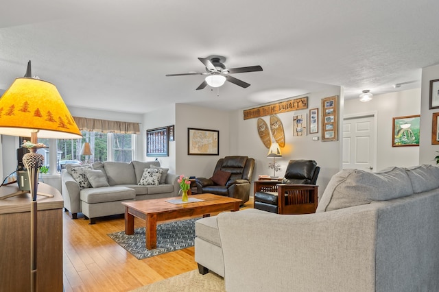 living area featuring light wood-style flooring and ceiling fan