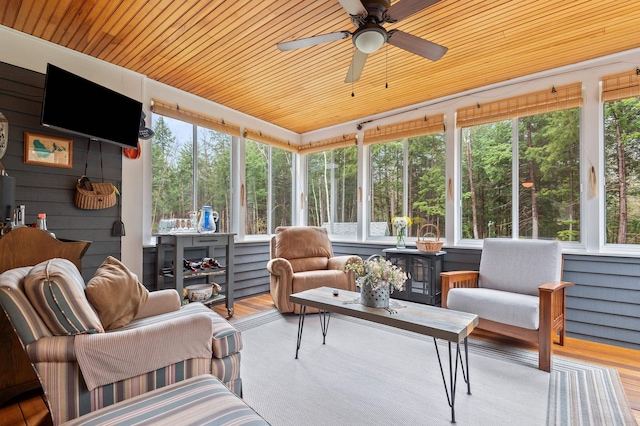 sunroom featuring wooden ceiling, ceiling fan, outdoor lounge area, and wood finished floors