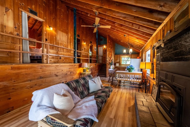 living room featuring lofted ceiling, wood walls, hardwood / wood-style floors, and ceiling fan
