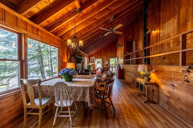 dining space featuring an inviting chandelier, wood ceiling, wood walls, beamed ceiling, and hardwood / wood-style flooring