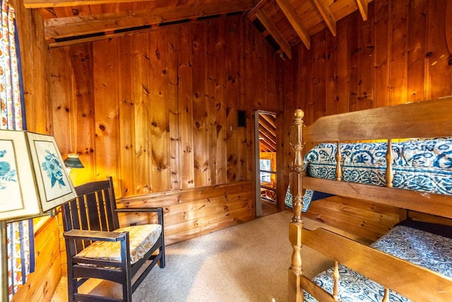 carpeted bedroom with wooden walls, wood ceiling, and vaulted ceiling with beams