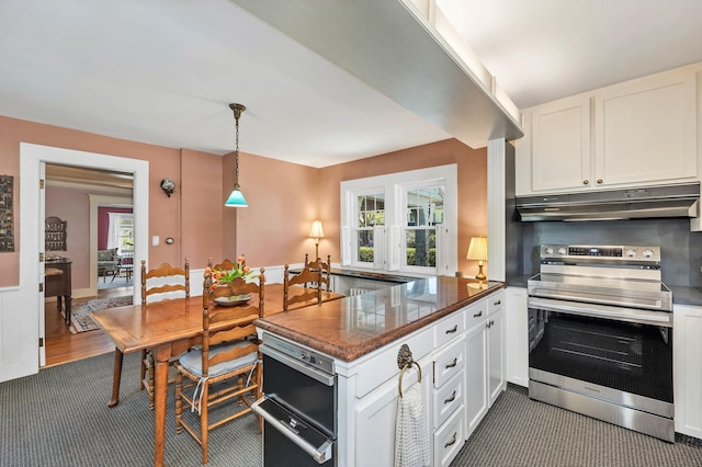 kitchen featuring dark carpet, white cabinets, under cabinet range hood, and electric range