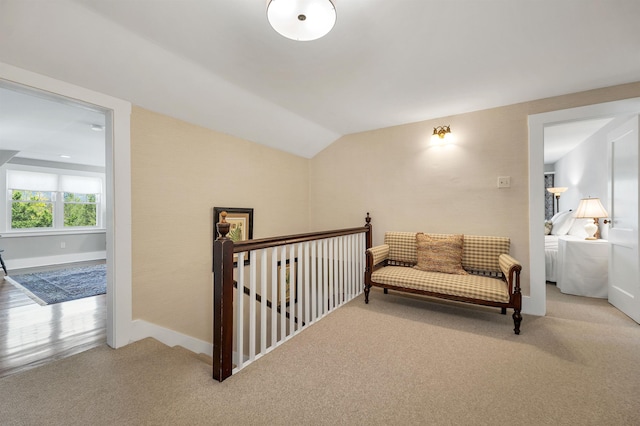 living area featuring baseboards, an upstairs landing, lofted ceiling, and carpet floors
