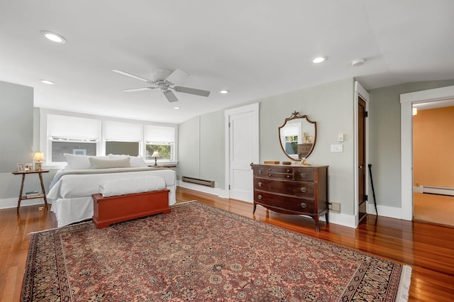 bedroom with a baseboard heating unit, recessed lighting, baseboard heating, and wood finished floors