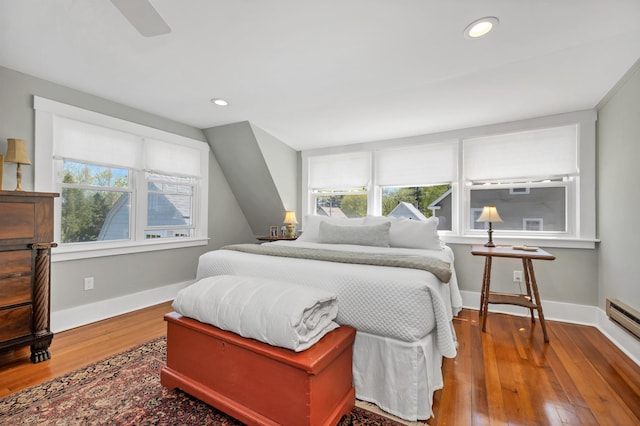 bedroom featuring a baseboard radiator, hardwood / wood-style flooring, baseboards, and recessed lighting