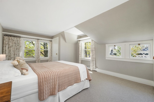 bedroom featuring a baseboard heating unit, vaulted ceiling, carpet flooring, and baseboards