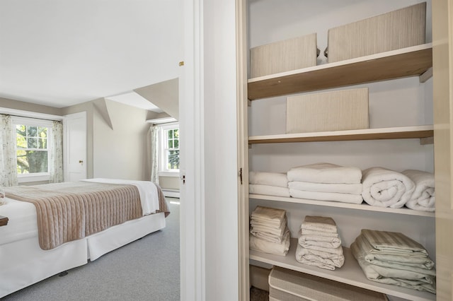 carpeted bedroom featuring a baseboard heating unit