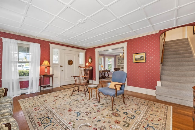 interior space with ornamental molding, wood-type flooring, and wallpapered walls