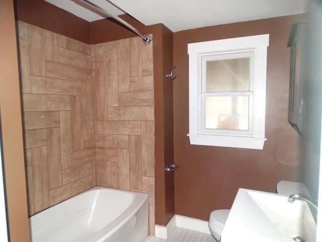 full bathroom featuring a sink, toilet, tile patterned floors, tub / shower combination, and baseboards