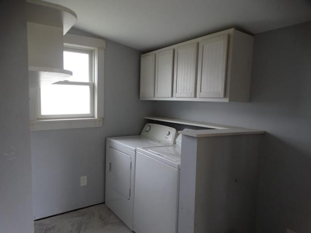 washroom with marble finish floor, cabinet space, and washer and clothes dryer