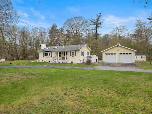 view of front of house featuring an outdoor structure, a detached garage, a chimney, and a front yard
