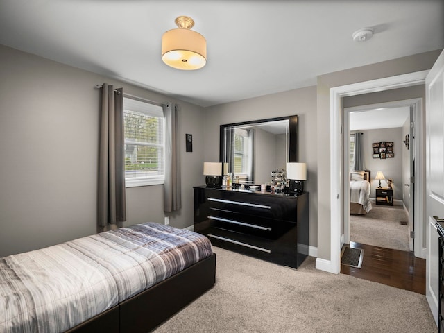 bedroom with baseboards, visible vents, and dark carpet