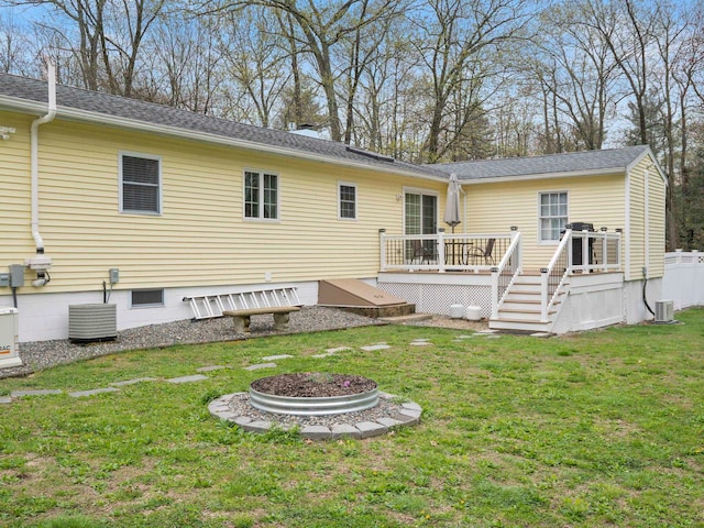 rear view of house featuring central AC unit, a wooden deck, fence, and a yard