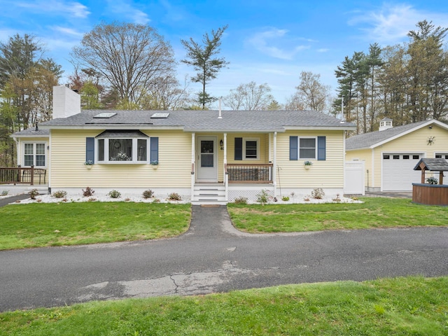 single story home featuring covered porch, a garage, a chimney, a front lawn, and an outbuilding