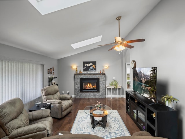 living room featuring lofted ceiling with skylight, a fireplace, ceiling fan, and wood finished floors