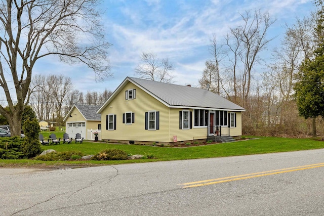 view of front of property featuring a front lawn, a garage, and metal roof