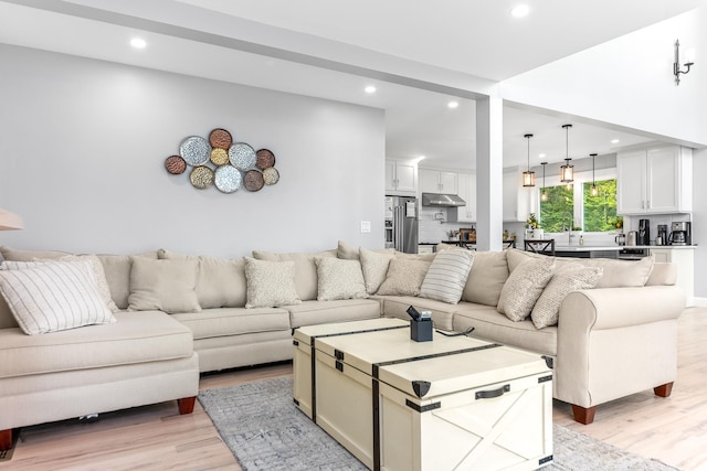 living area with light wood-style floors and recessed lighting