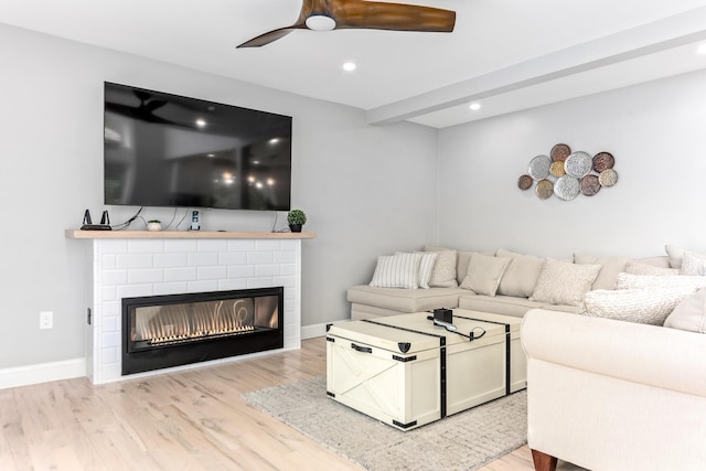 living area featuring a fireplace, ceiling fan, recessed lighting, and wood finished floors