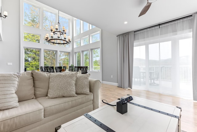 living area featuring recessed lighting, ceiling fan with notable chandelier, baseboards, and wood finished floors