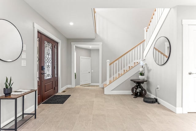 entrance foyer featuring baseboards, stairs, and recessed lighting