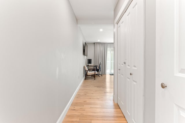corridor featuring light wood finished floors, baseboards, and recessed lighting