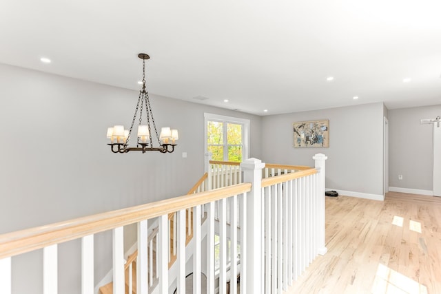 corridor with a chandelier, recessed lighting, baseboards, and wood finished floors