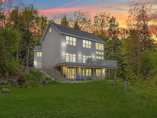 rear view of property featuring a yard and a wooden deck