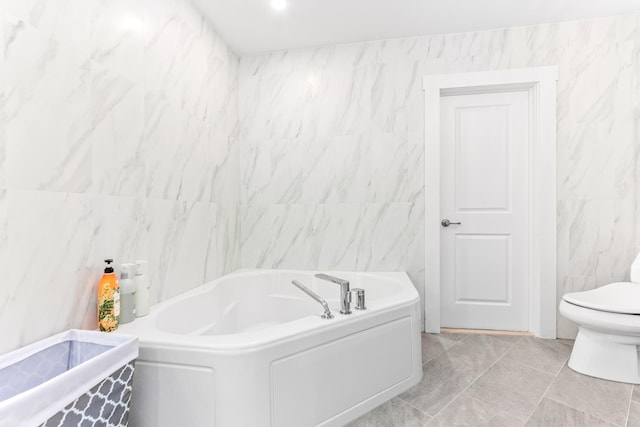 bathroom featuring a bath, toilet, and tile walls