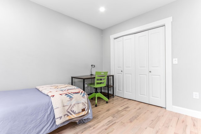 bedroom with baseboards, a closet, and wood finished floors