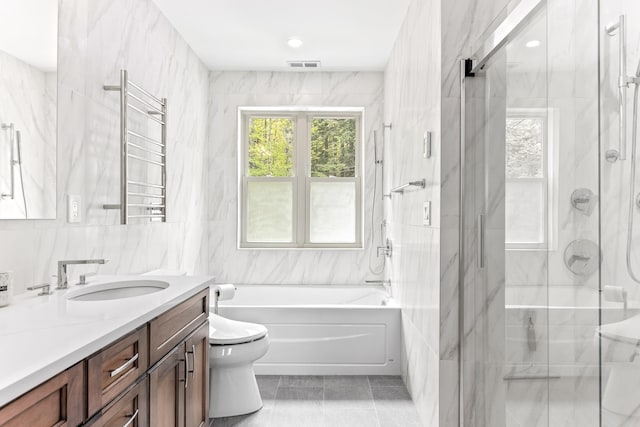 full bathroom with toilet, tile walls, a wealth of natural light, and a shower stall