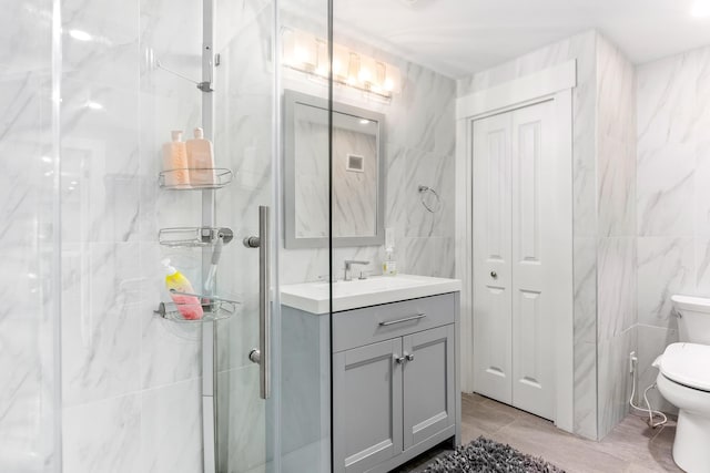 full bathroom featuring toilet, tile walls, vanity, and a stall shower