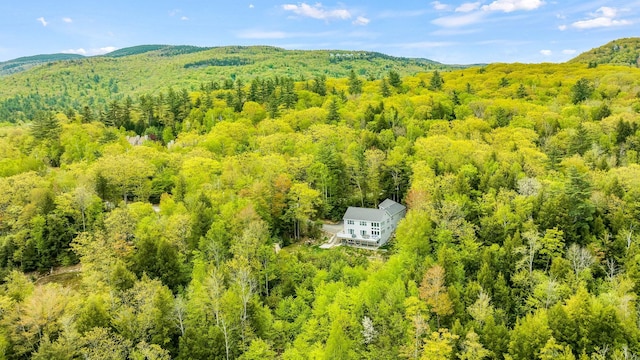 aerial view featuring a wooded view and a mountain view