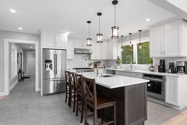 kitchen with backsplash, stainless steel appliances, and a sink