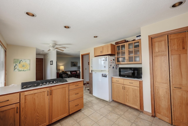 390 Bear Hill Rd, Loudon, NH 03307 - kitchen with freestanding refrigerator, stainless steel gas cooktop, ceiling fan, black microwave, and glass insert cabinets