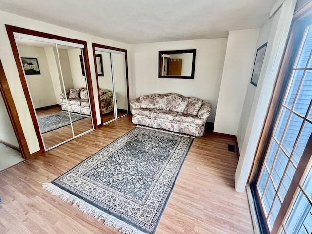 living area with baseboards and wood finished floors