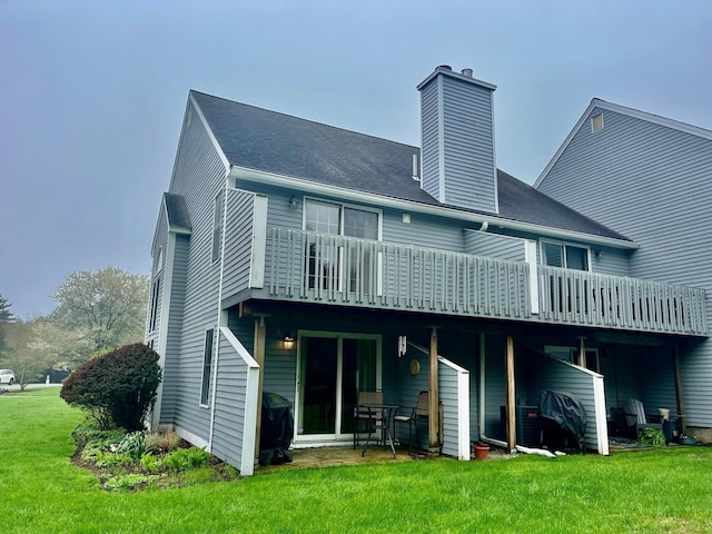 rear view of house featuring a yard, a chimney, and a deck