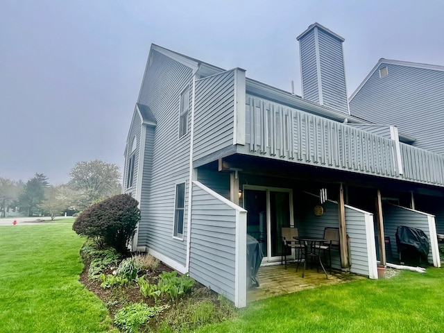 back of house featuring a patio area, a deck, and a lawn