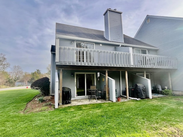 back of property featuring a yard, a deck, a patio, and a chimney