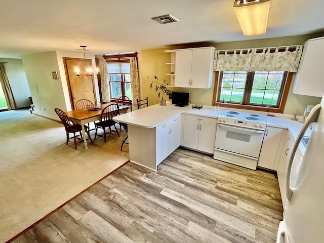 kitchen featuring a peninsula, white cabinets, a healthy amount of sunlight, and white range with electric cooktop