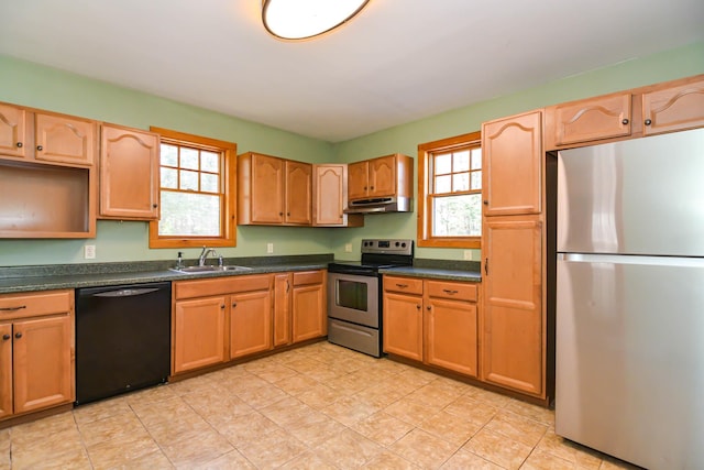 kitchen featuring dark countertops, stainless steel appliances, a sink, and under cabinet range hood