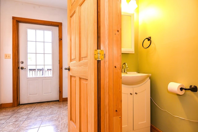 bathroom with vanity, baseboards, and tile patterned flooring