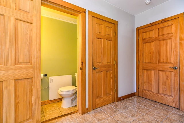 bathroom featuring tile patterned flooring, toilet, and baseboards