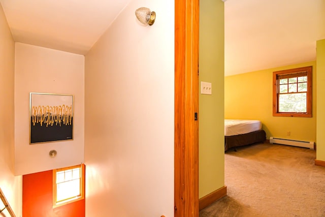 corridor featuring a baseboard heating unit, carpet flooring, and baseboards