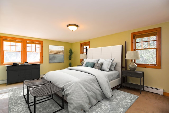 bedroom with a baseboard radiator, baseboards, and multiple windows