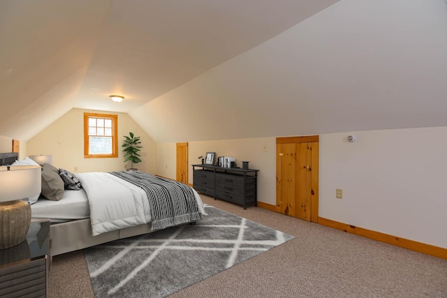 carpeted bedroom with baseboards and vaulted ceiling