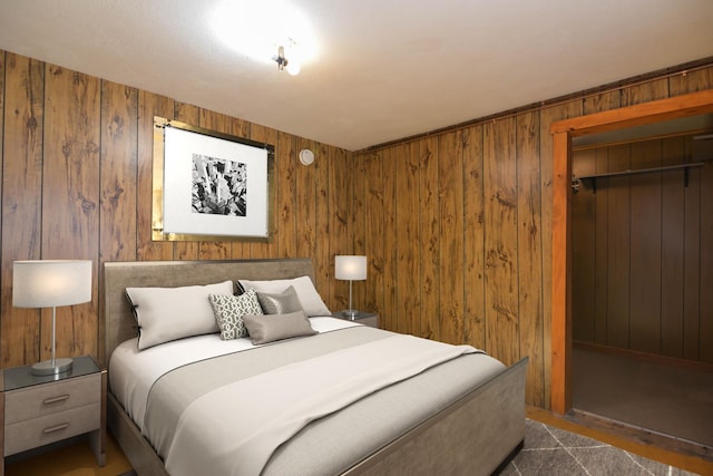 bedroom with wood walls and a closet