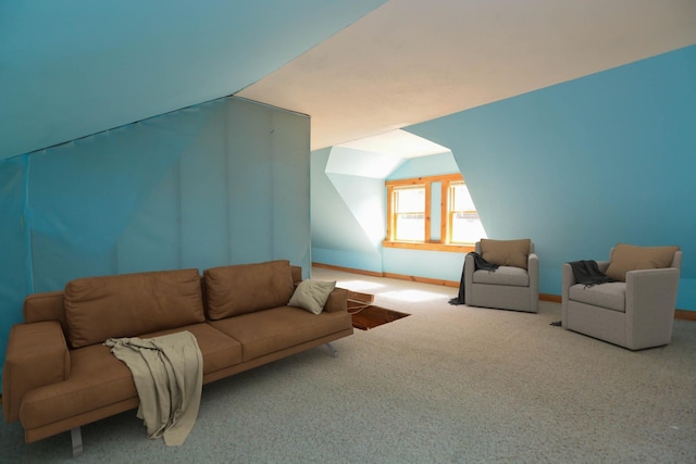 carpeted living area featuring vaulted ceiling and baseboards
